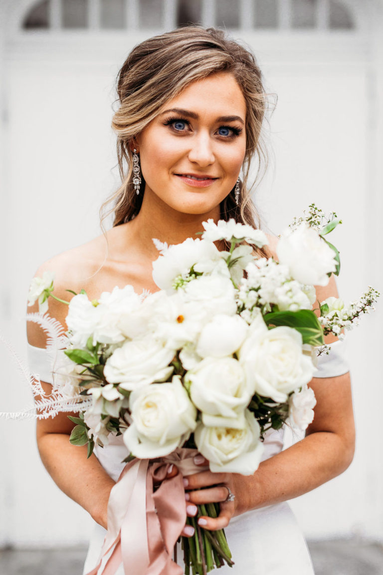 bride smiles while holding her bouquet