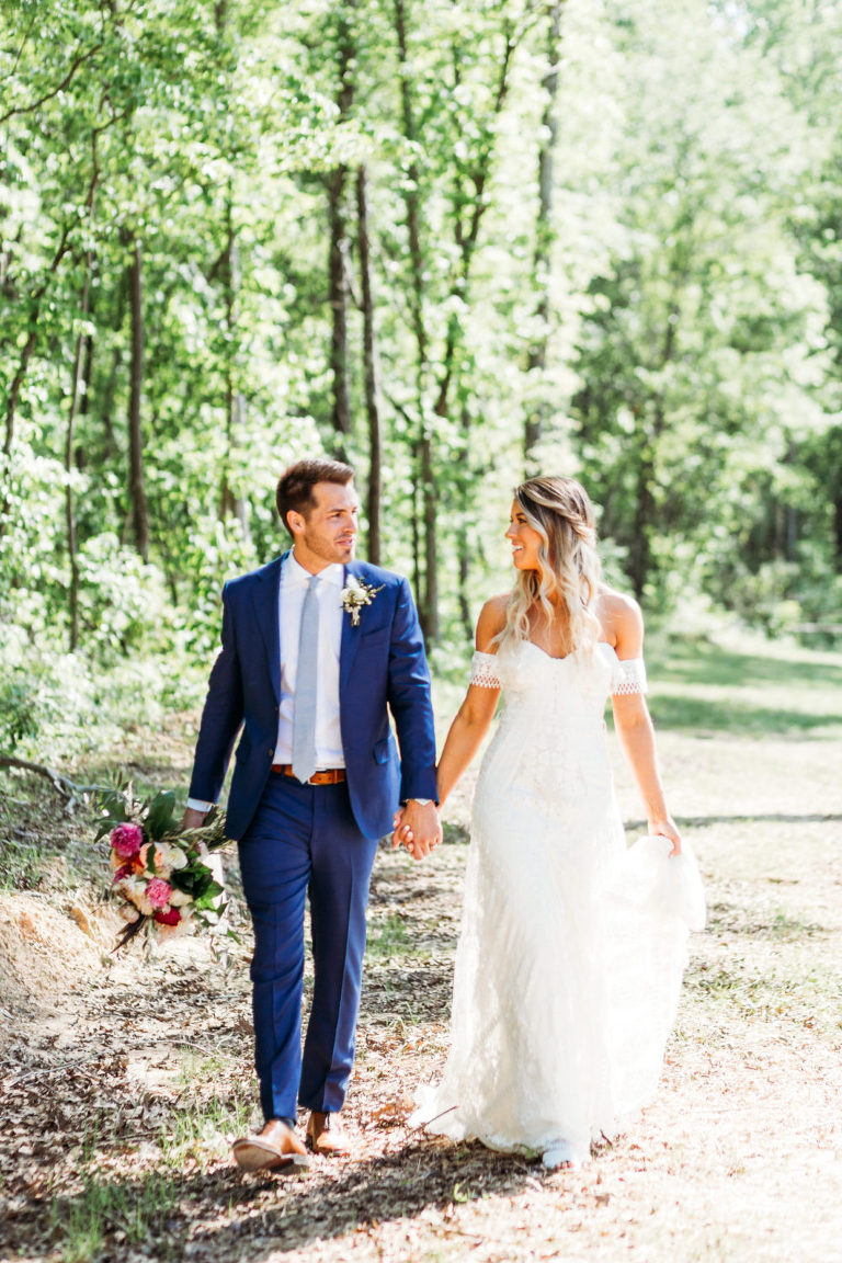 bride and groom walk hand in hand