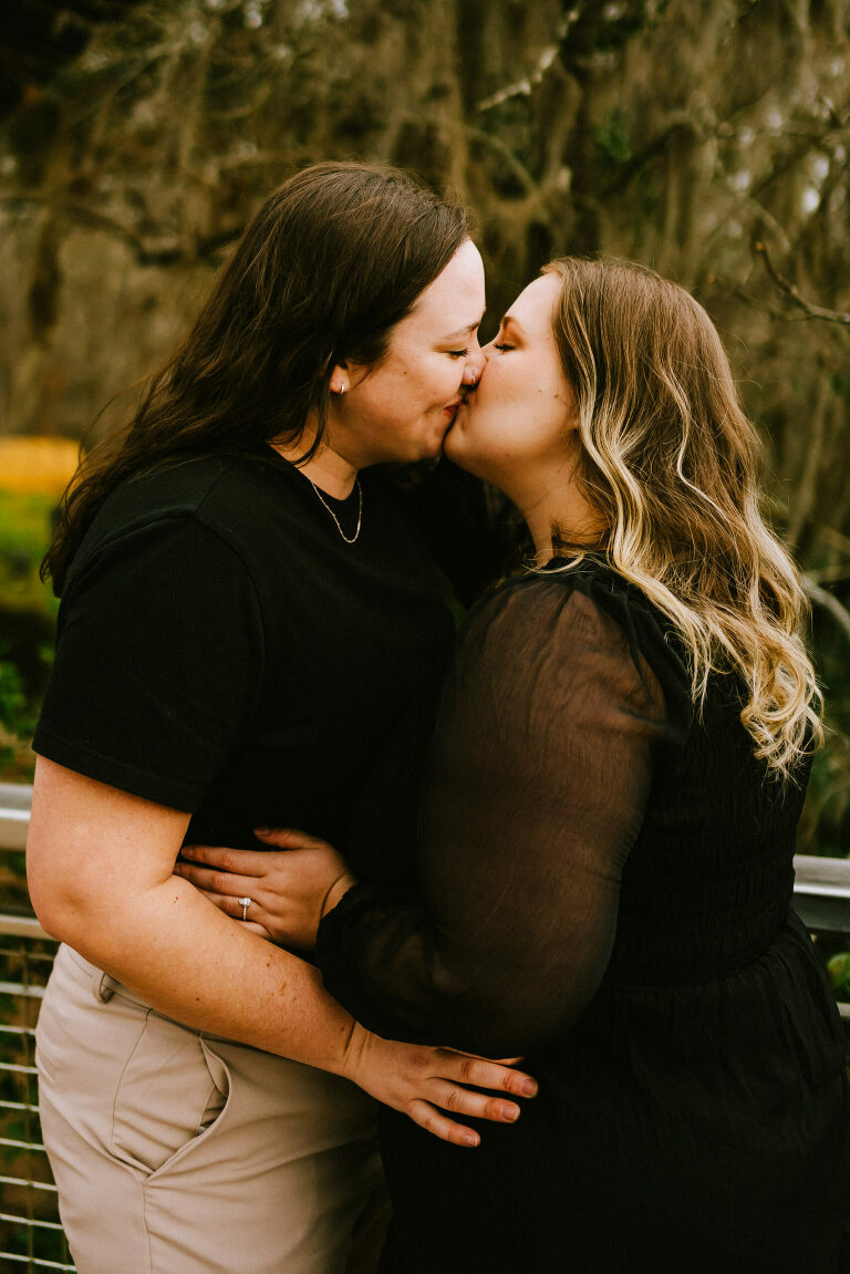 two women kissing each other during their engagement session