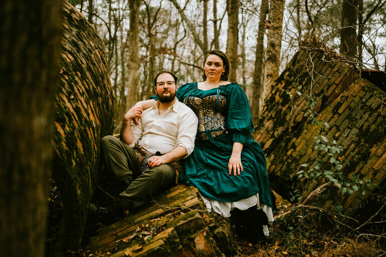 couple posing in chimney ruins while wearing renfaire attire