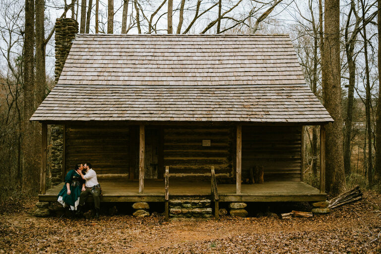 couple kissing on a cabin porch while wearing renfaire attire