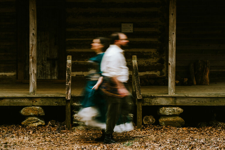 couple walking in front of a cabin while wearing renfaire attire