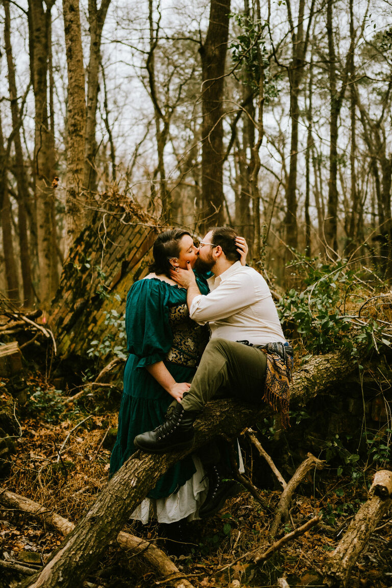 couple kissing in the woods while wearing renfaire attire